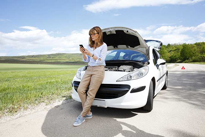 Eine Frau mit einer KFZ Versicherung von AXA hat eine Fahrzeugpanne Eine Frau mit einer KFZ Versicherung von AXA hat eine Fahrzeugpanne