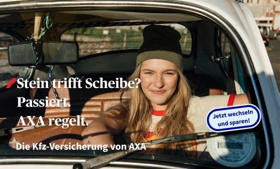 Eine junge Frau sitzt im Auto und lächelt.