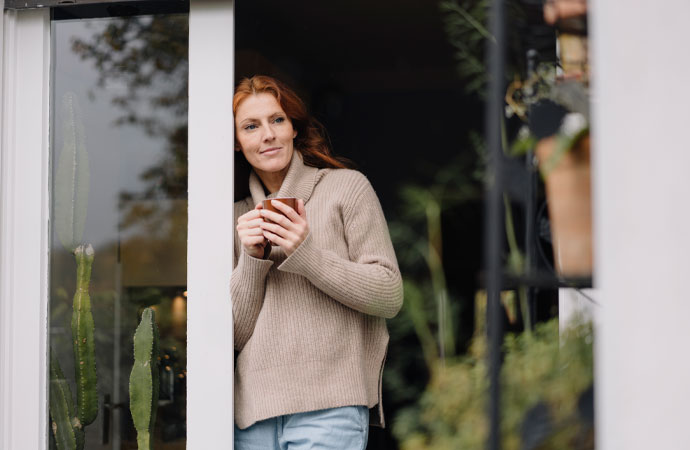 AXA Bremen fair Finanzpartner oHG | Wohngebäudeversicherung Frau stehend an der Terassentür AXA Bremen fair Finanzpartner oHG | Wohngebäudeversicherung Frau stehend an der Terassentür