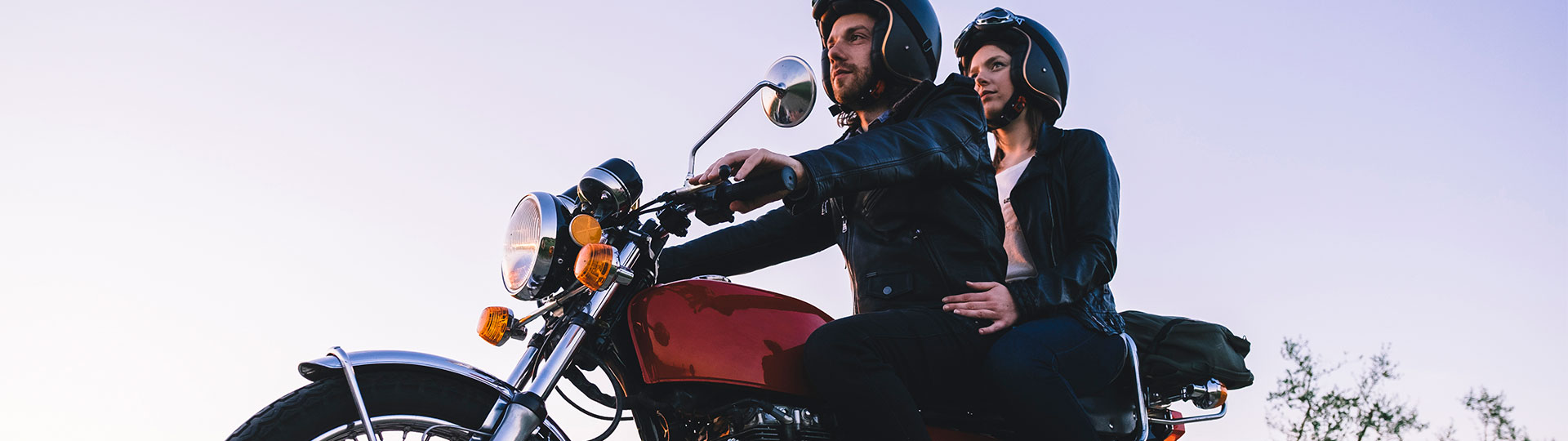 Pärchen sitzt zusammen auf einem Motorrad