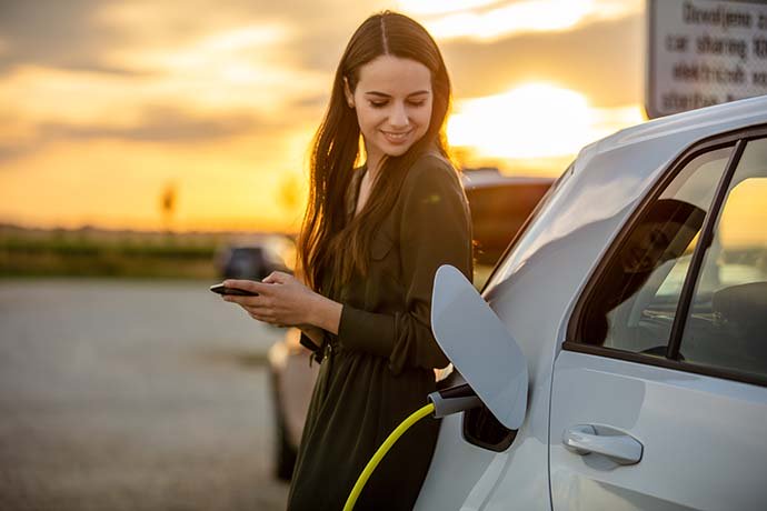 Frau ladet Ihr Elektroauto auf Frau ladet Ihr Elektroauto auf
