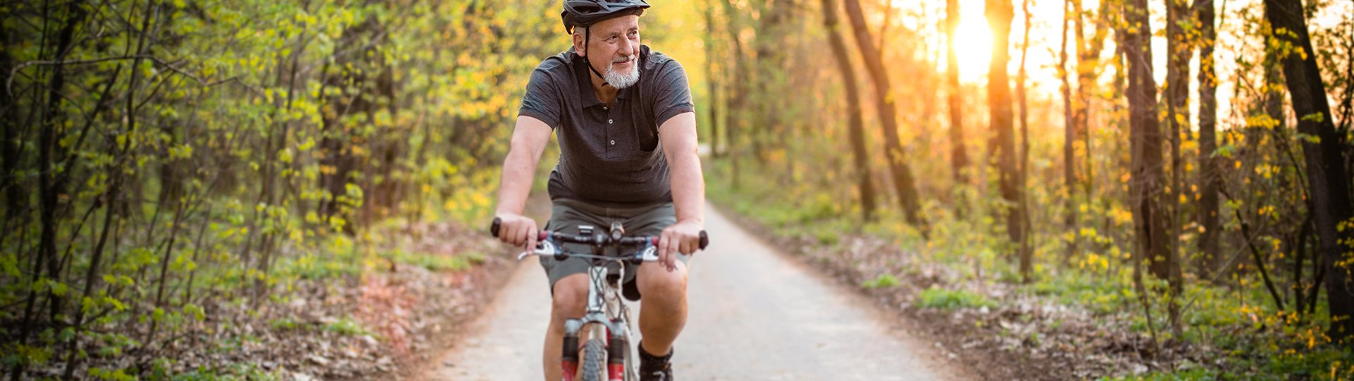 Mann fährt auf einem Fahrrad auf einem Waldweg